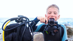 Junge mit Atemregler und Tauchausrüstung / Fotolia